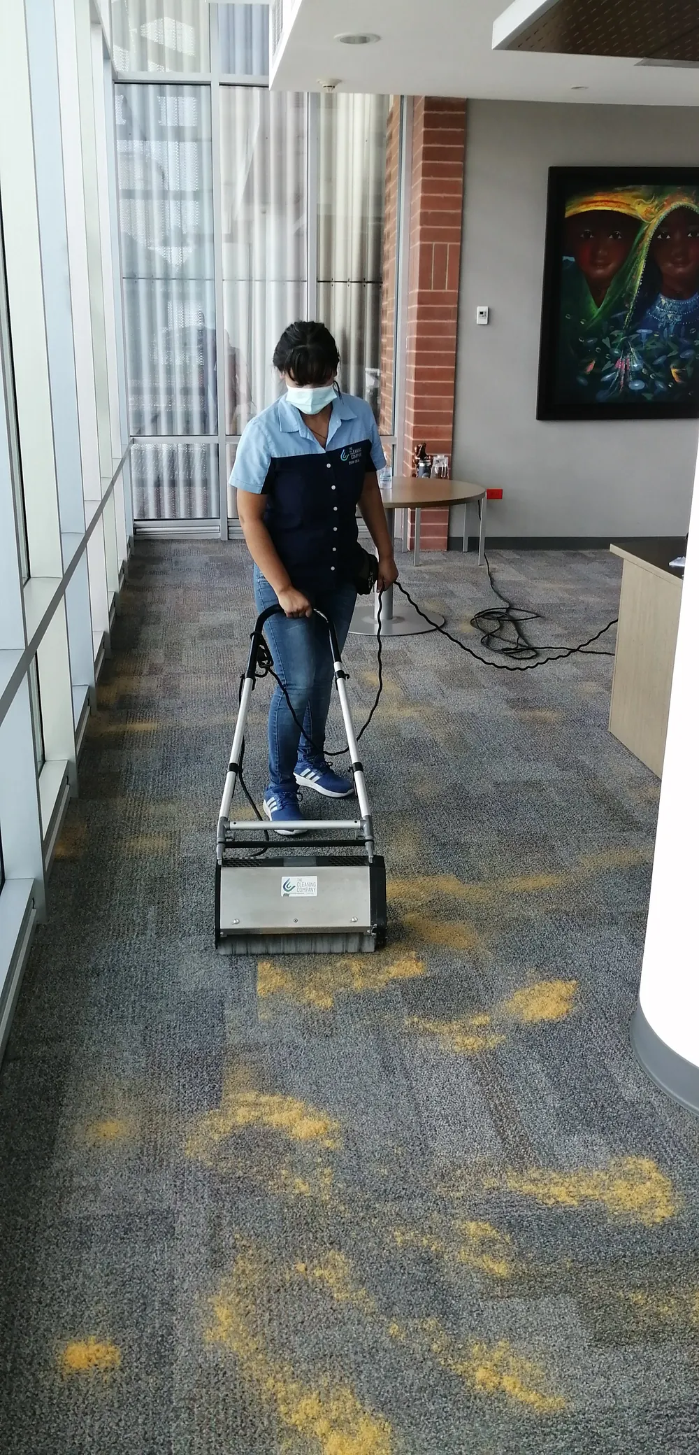 Técnico aplicando compuesto de encapsulación sobre alfombra de oficina